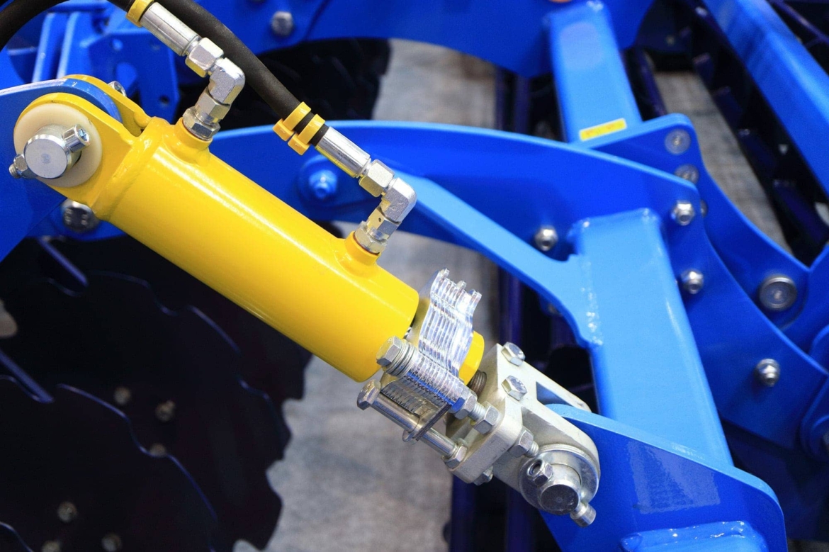 A blue machine with a yellow handle available for purchase at a machine shop specializing in hydraulics.