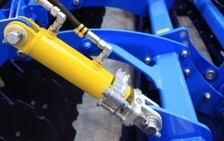 A blue machine with a yellow handle available for purchase at a machine shop specializing in hydraulics.